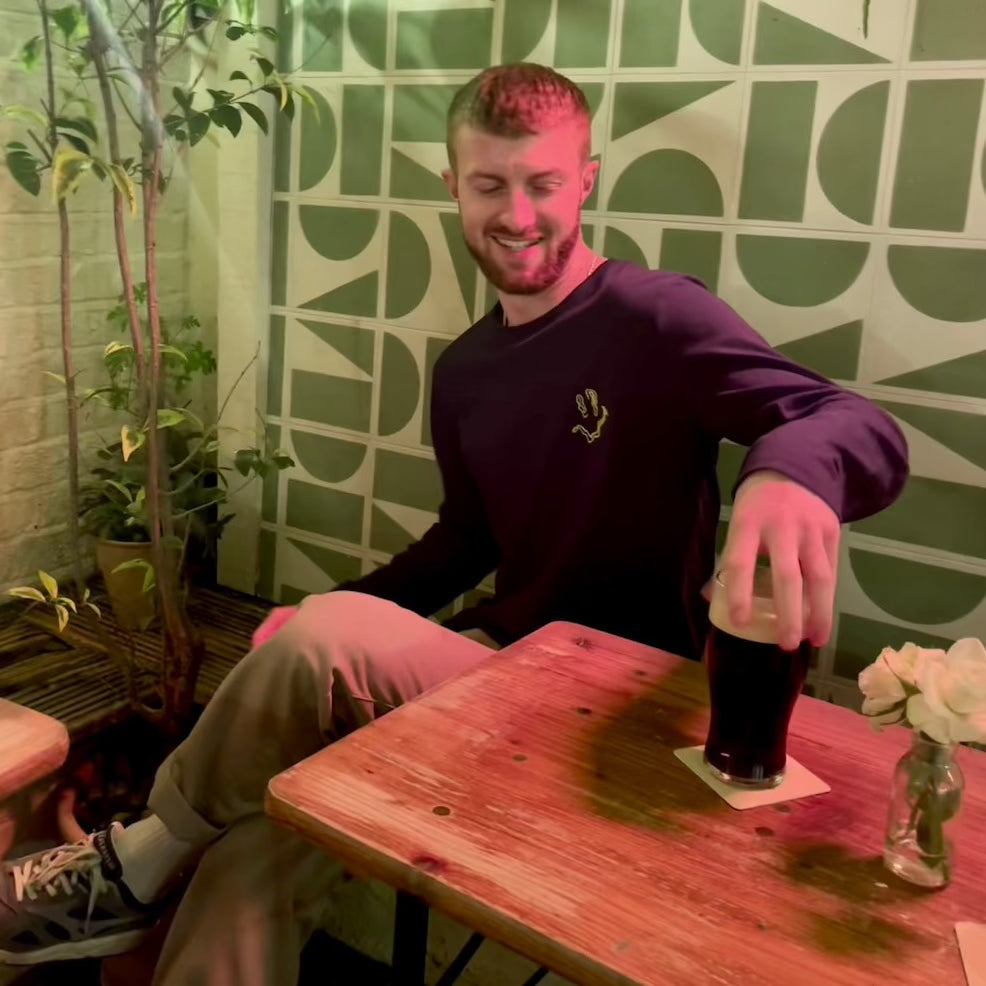 Model wears SMILE HIGH CLUB Black Long Sleeve T-Shirt - Hun Sauce - smiley disco rave poster, for house music, techno and disco. One for the dancefloor and Rave Wardrobe