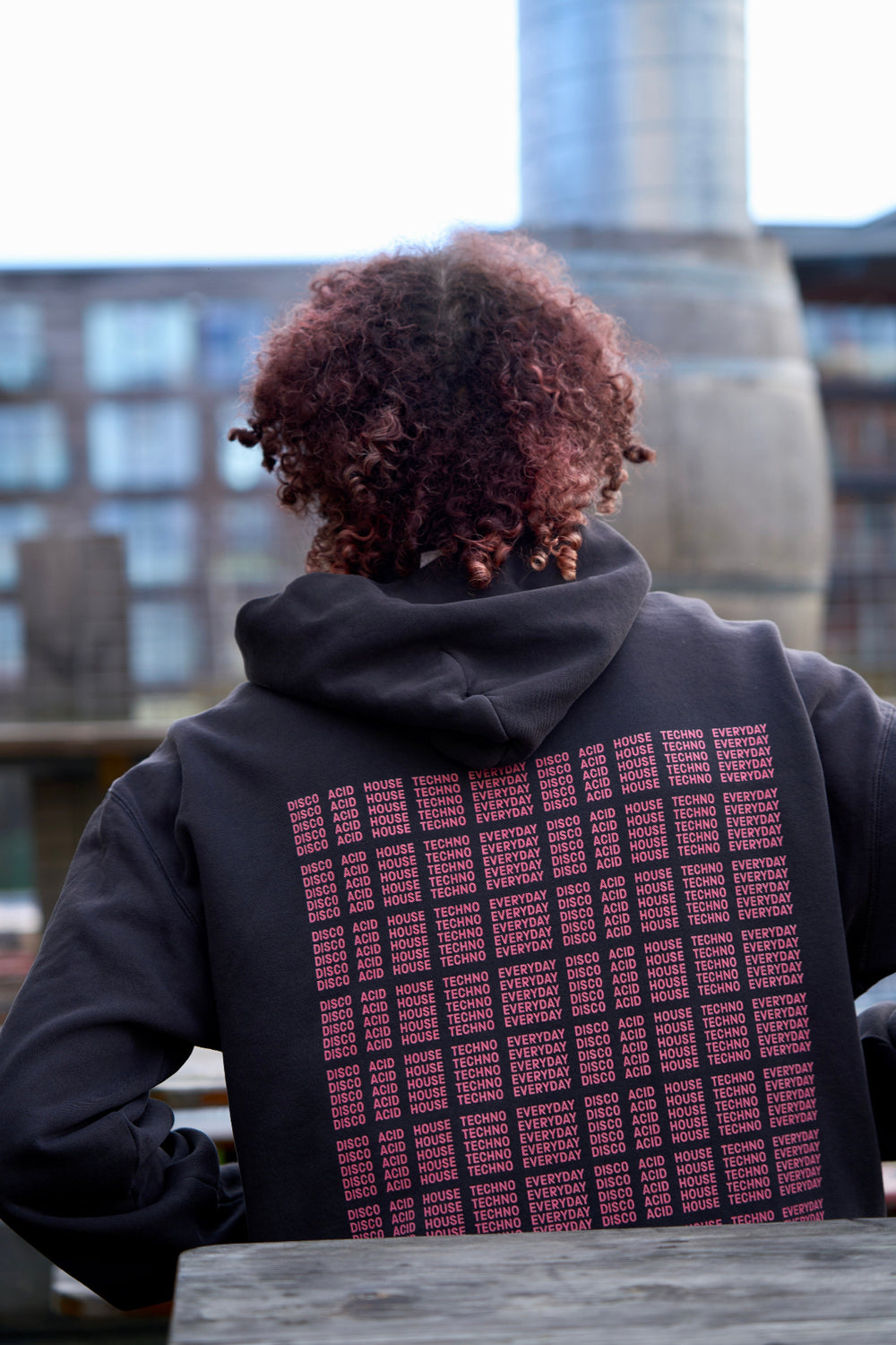 Model in I'M NOT A DJ Hoodie - Hun Sauce, Black hood for DJs. I'm not disc jockey collection for the rave. Heavyweight hood. Now available at the record store at All My Friends, in Hackney.