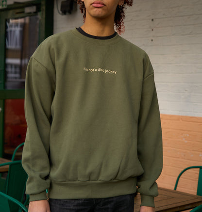 Model wears I'M NOT A DJ Heavyweight Sweater, Rave Streetwear, Graphic DJ Sweat, By Hun Sauce. Independent streetwear brand. Now stocked at All My Friends, store, Hackney Wick.