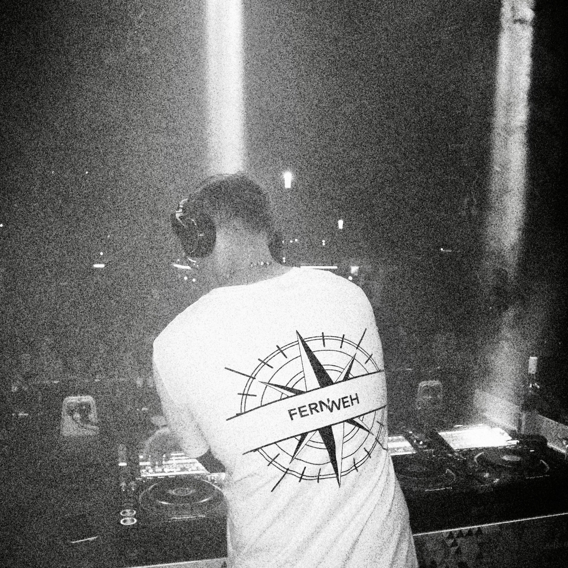DJ Fernweh wearing custom Hun Sauce white T-shirt with cleaned-up logo and embroidered caps featuring a remix of the Hun Sauce smiley, photographed at Weinfestival Koblenz by Luca Di Stefano.